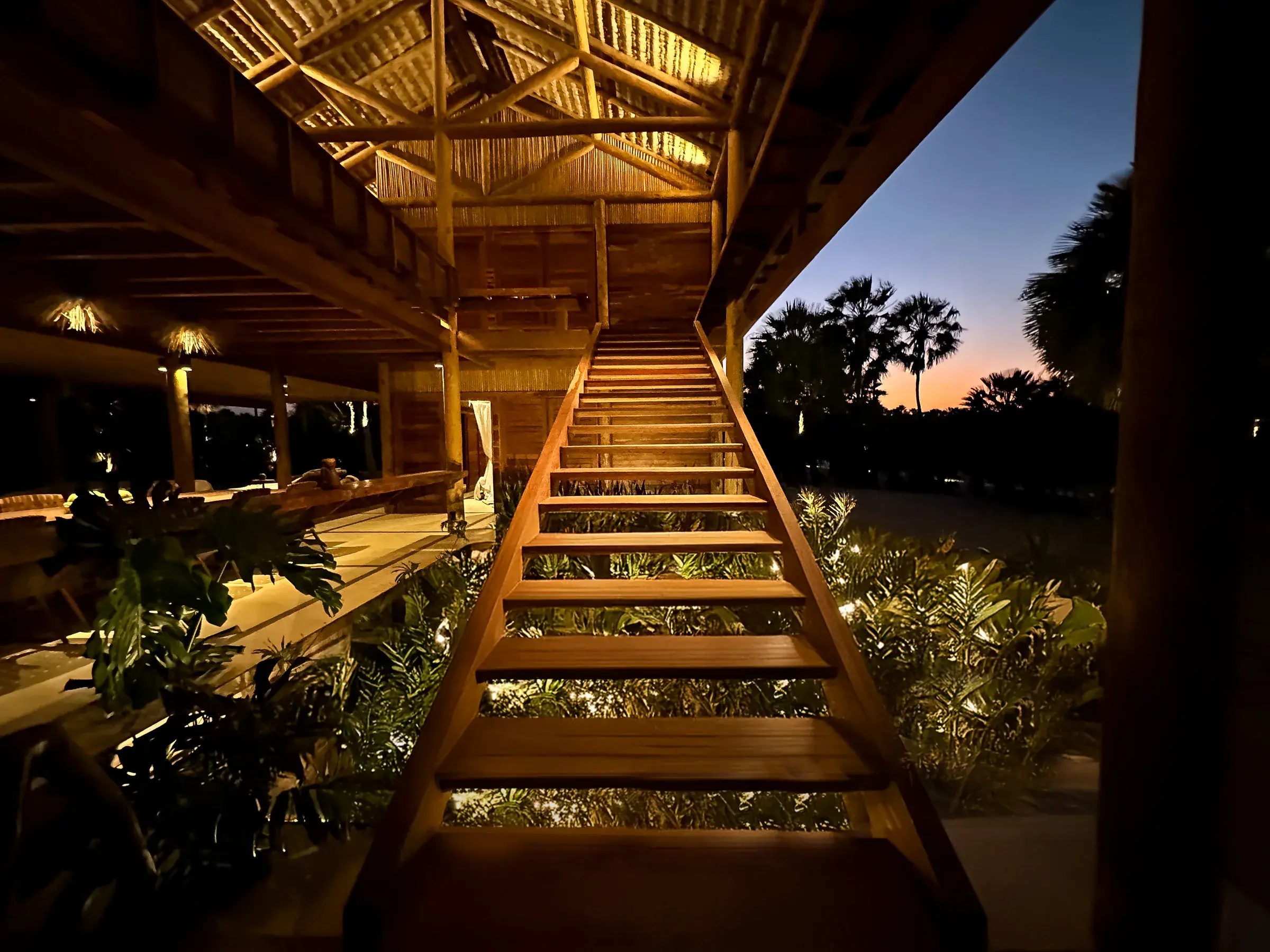 Casa Camuá — timber staircase at dusk
